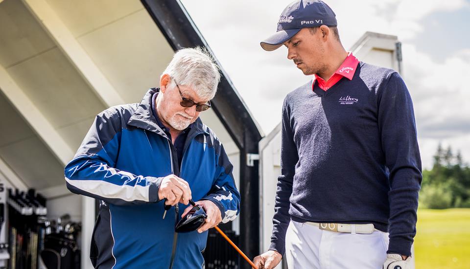 Golf træner fikser kølle til spiller