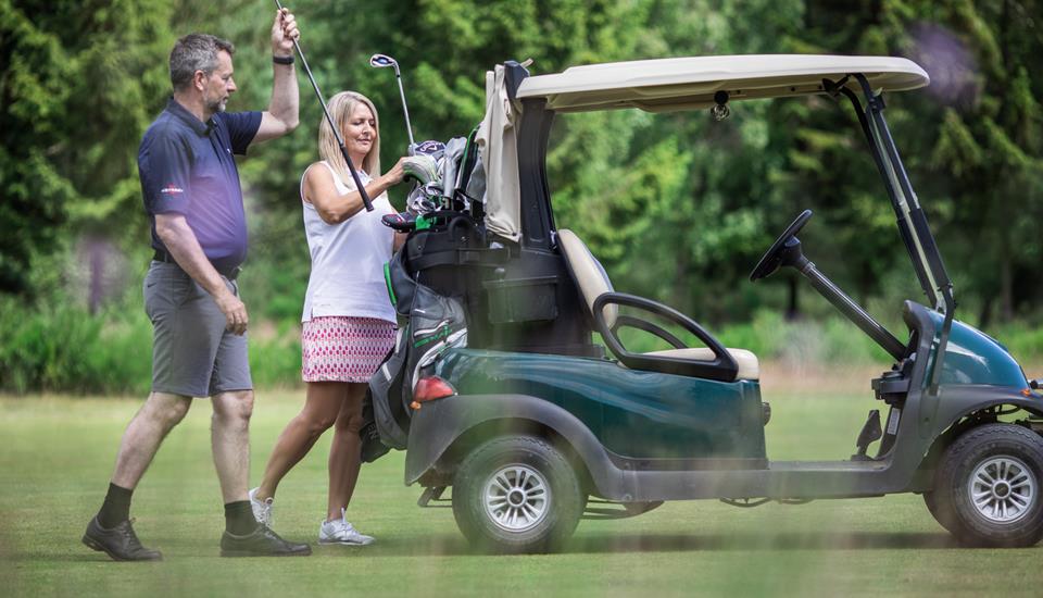to golfspillere tager køller ved deres golfvogn